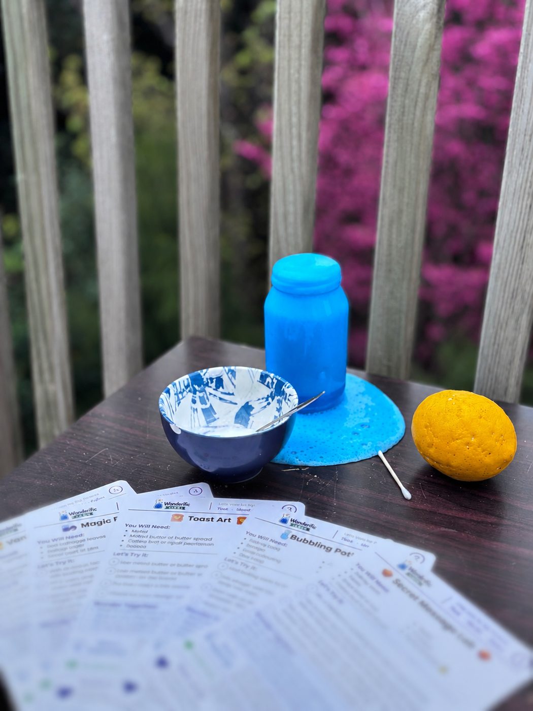 A fizzing blue jar spilling over a table with the Magic and Mixtures activity cards spread out in front